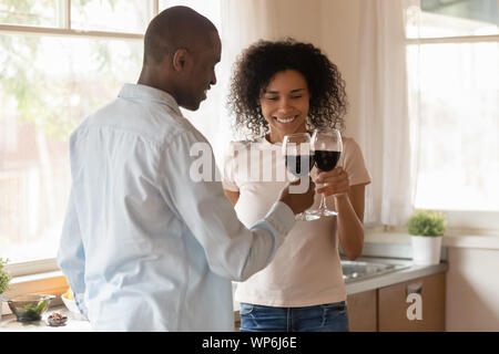 Amare biracial giovane clink bicchieri celebrando aventi data Foto Stock