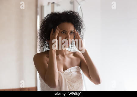 Ansiosi americano africano donna preoccupati per viso rughe Foto Stock