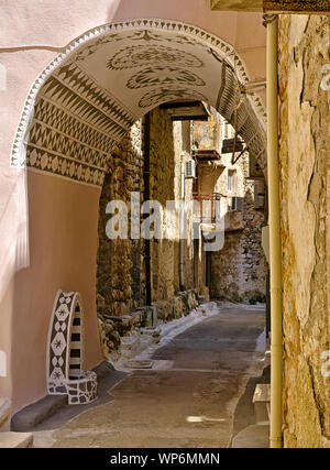 Vicolo stretto decorate con tunnel in Pyrgi borgo medievale, Chios Island, Grecia. Foto Stock