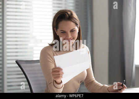 Leader sorridente tenendo la documentazione cartacea, rivedendo i dettagli del contratto. Foto Stock