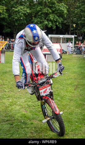 Stunt rider Steve Colley di eseguire un trick a Llan Bike Fest, il motociclo Llangollen Festival, in Galles Foto Stock