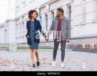 Gli amanti della millenaria camminando per strada, tenendo le mani Foto Stock