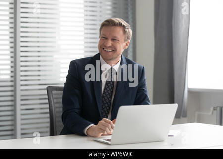 Happy businessman ridendo, ascolto per scherzo, divertirsi presso l'ufficio. Foto Stock