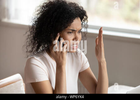 Biracial infelice donna avente sgradevole chiamata di cellulare Foto Stock