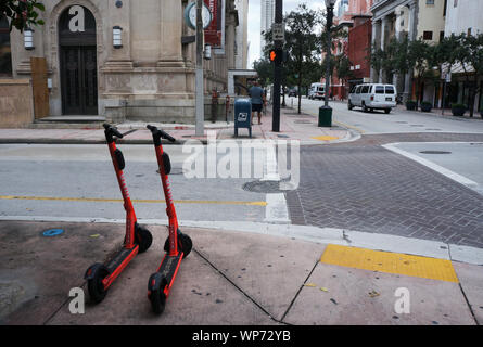 Vista NE prima strada e ne 1st Avenue nel quartiere storico del centro di Miami con due scooter elettrici disponibili per affitto Foto Stock