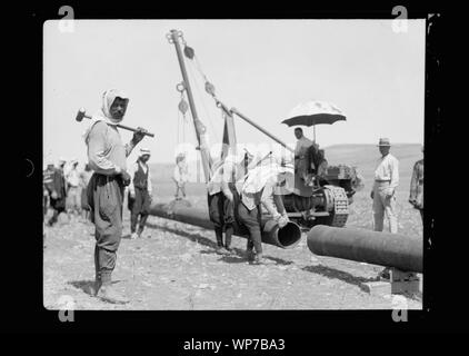 Posa del Iraq Petroleum Company la tubazione per tutta la pianura di Esdraelon, luglio 1933. Tubi di oscillazione in posizione. Gru del trattore durante il lavoro Foto Stock