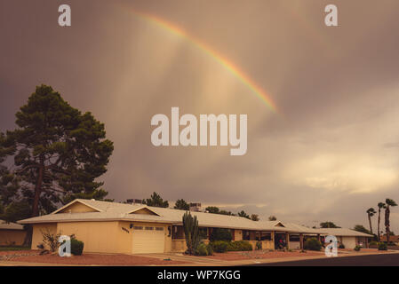 Fotografia analogica di un arcobaleno al di sopra di un ranch uno stile-storia home a Sun City, in Arizona. Foto Stock