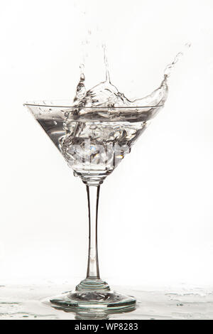 Vetro, cristalli di ghiaccio e versando acqua su isolati di sfondo per studio Foto Stock