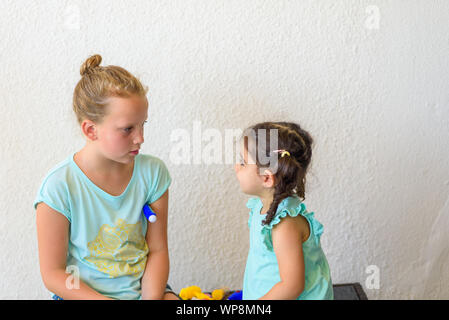 Bambini che giocano medico. Carino il toddler girl con termometro a giocare con la sua sorella adolescente. Foto Stock