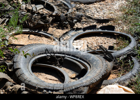 Vecchi pneumatici accatastati, Close-up rotto pneumatico danneggiato, un mazzetto di vecchi pneumatici di automobili usate. Inquinamento ambientale. Pneumatici di dump Foto Stock