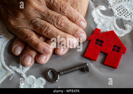 Vecchia donna mano con house e chiave Foto Stock