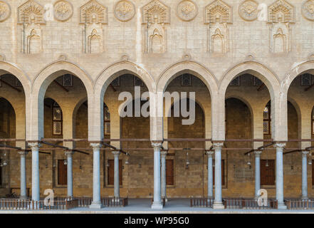 Corridoio arcuato che circondano il cortile della pubblica antica moschea di Sultan Al Moaayad, vecchio Cairo, Egitto Foto Stock