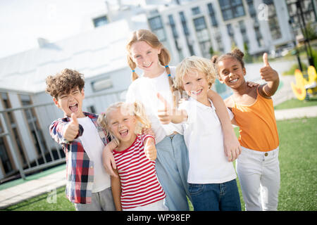 Allegro bambini sentirsi veramente felice dopo la sorprendente giornata a scuola Foto Stock