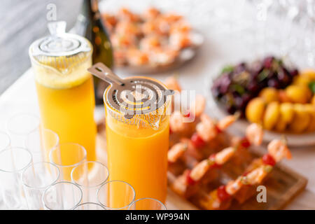 Banca di vetro di limonata con spicchi di agrumi su un tavolo da buffet. Summer party all'aperto. Detox. Foto Stock