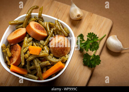 Stufato preparato da piselli verdi con salsiccia di maiale in vaso - vista superiore Foto Stock