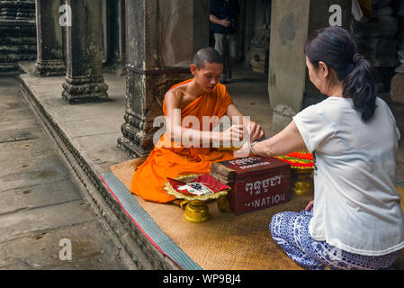 Monaco buddista benedizione di persone nel cortile centrale all'interno di Angkor Wat, Siem Reap, Cambogia Foto Stock
