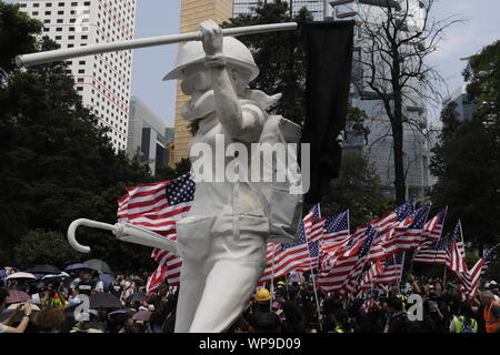 Hong Kong, Cina. 8 Sep, 2019. Bandierine americane onde dietro un deriso fino "dea della democrazia' vestito in pieno gli indumenti di protezione in carta giardino.Migliaia di cittadini hanno marciato al Consolato Americano chiamata generica Washington per back HK i diritti umani e la democrazia atto questo pomeriggio.Sept-8, 2019 Hong Kong.ZUMA/Liau Chung-ren Credito: Liau Chung-ren/ZUMA filo/Alamy Live News Foto Stock