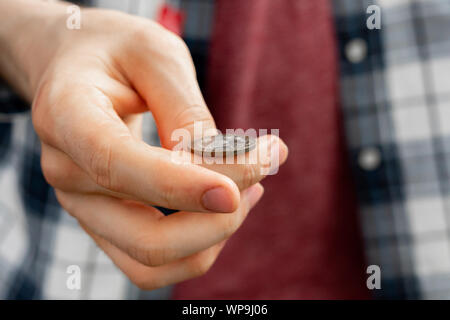 Immagine ravvicinata di mano lanciare una moneta, probabile e le possibilità di vincita concetto, fifty-fifty s Foto Stock