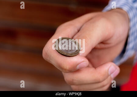 Immagine ravvicinata di mano lanciare una moneta, probabile e le possibilità di vincita concetto, fifty-fifty s Foto Stock