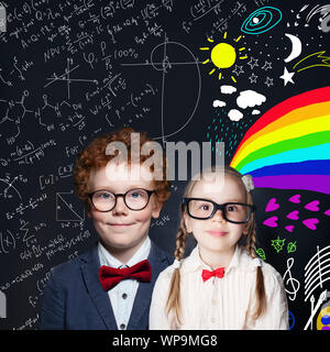 Carino bambini ritratto. Scuola sorridente ragazza e ragazzo su sfondo blackboard Foto Stock