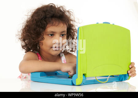 Girl using a toy laptop Stock Photo