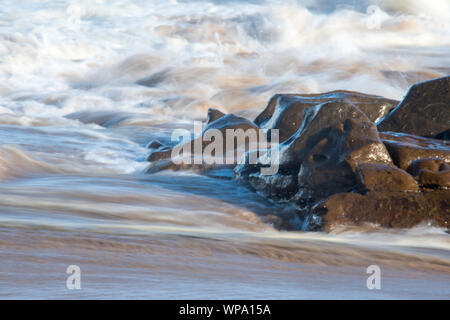 Fotografie astratte di seascape con forte risacca con otturatore a bassa velocità e la sfocatura del movimento. Foto Stock