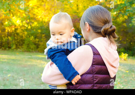 La madre e il bambino in autunno park Foto Stock