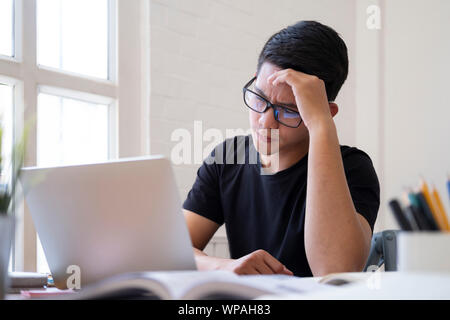 Dubbio studenti che lavorano su compiti o attività di ricerca. Riflessivo pensieroso serio studente maschio pensando al progetto di pianificazione analisi di prendere decisioni Foto Stock