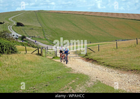 Due ciclisti persone in bicicletta in bicicletta su un sentiero su una collina sulla South Downs Way a East Sussex Downs Inghilterra Gran Bretagna UK KATHY DEWITT Foto Stock