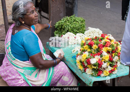 Le donne indiane che vendono fiori al di fuori del tempio di Srirangam nella città di Trichy Foto Stock