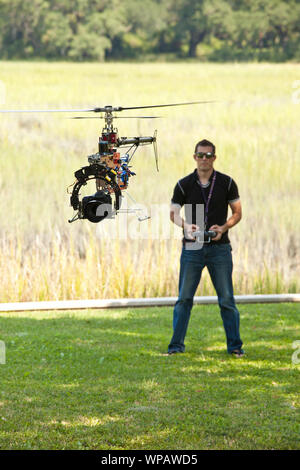 L'uomo controllo elicottero drone, UAV con SLR Fotocamera collegata. Foto Stock