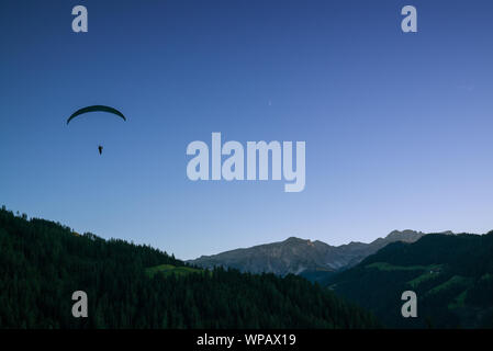 Silhouette di parapendio in Dolomite paesaggio di montagna al tramonto vicino a Wengen Foto Stock