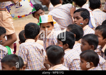 Un gruppo della scuola elementare i bambini seduti sulla terra durante il giorno di indipendenza di India Foto Stock