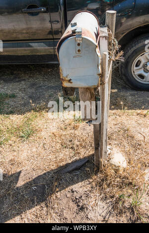 Battere la cassetta postale, arrugginiti e trattenuta dal paletto di legno e di corda in Santa Barbara County, California. Foto Stock