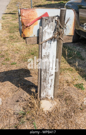 Battere la cassetta postale, arrugginiti e trattenuta dal paletto di legno e di corda in Santa Barbara County, California. Foto Stock
