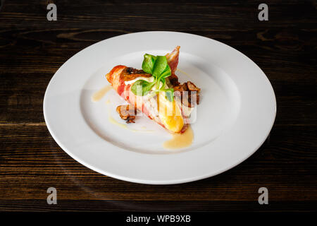 Pancetta fritta con uovo in camicia, funghi e insalata mista Foto Stock