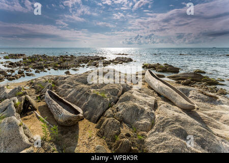 Sunrise vista lago Malawi, onde regolare scorrimento sulla spiaggia, due di legno albero di una barca in primo piano, Africa Foto Stock