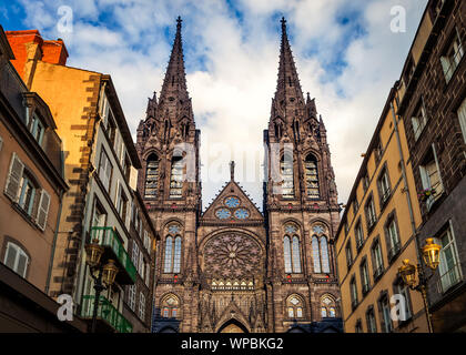 Bella e imponente cattedrale gotica di Clermont Ferrand in Francia, realizzato da scure rocce vulcaniche alleggerire dal golden sunset luce solare Foto Stock