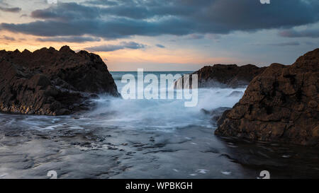 Onde infrangersi sulle rocce a Condino Spiaggia di North Devon, Regno Unito Foto Stock