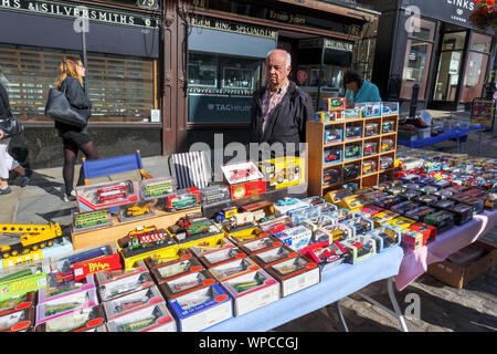 Una bancarella vendendo oggetti collezionabili vintage i veicoli giocattolo a Guildford Antique & Brocante Street Market, High Street, Guildford, Surrey, Inghilterra sudorientale, REGNO UNITO Foto Stock