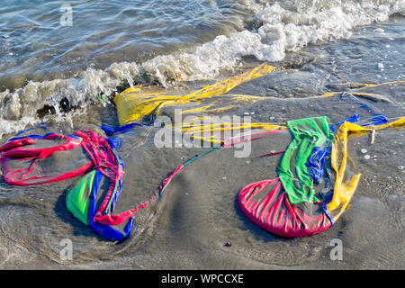 Marea depositato di poliestere colorato tenda, spiaggia costiera. Foto Stock