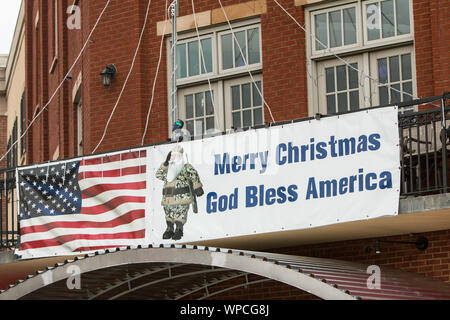 Un banner con una immagine di una armata di Santa Claus la lettura 'Buon Natale, Dio benedica l America' appeso su un edificio sul dicembre 15, 2018 in Suwanee GA. Foto Stock