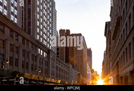 La luce del sole splende tra gli edifici lungo 34th Street in Midtown Manhattan, New York New York Foto Stock