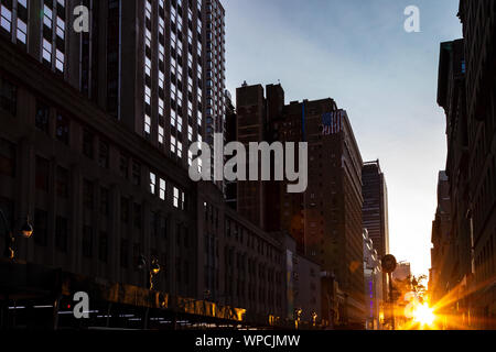 Luce di crepuscolo del tramonto del sole che splende su edifici lungo 34th Street nella città di New York New York Foto Stock
