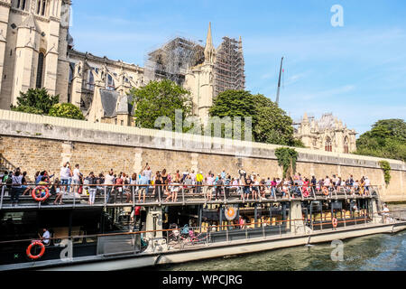 I turisti in tour in barca guarda bruciato la cattedrale di Notre Dame a Parigi Foto Stock