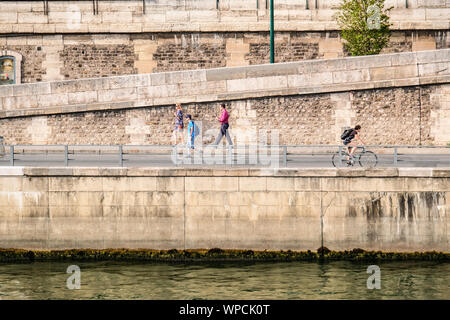 La gente di passeggiate e bicicletta sul molo di pietra lungo la Senna a Parigi Foto Stock