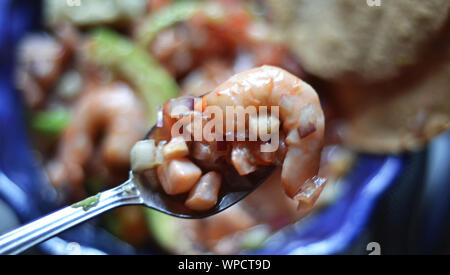 Close up di un piatto di frutti di mare, presa dal punto di vista della persona che è mangiare mentre si prepara da mangiare Foto Stock