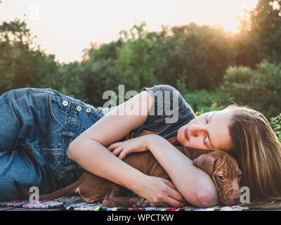Bella donna teneramente abbraccia un giovane cucciolo Foto Stock