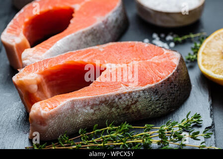 Pesce fresco. Materie non cotti filetti di salmone su ardesia. Cibo sano e ricco di acidi grassi omega 3 Foto Stock