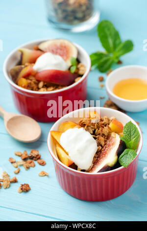 Fig e pesca granola croccante servita con crema di primo piano Foto Stock